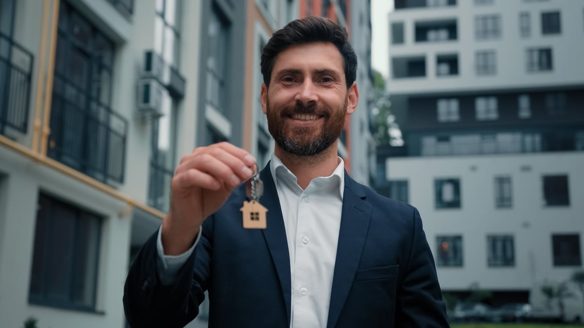 a businessman holding house keys