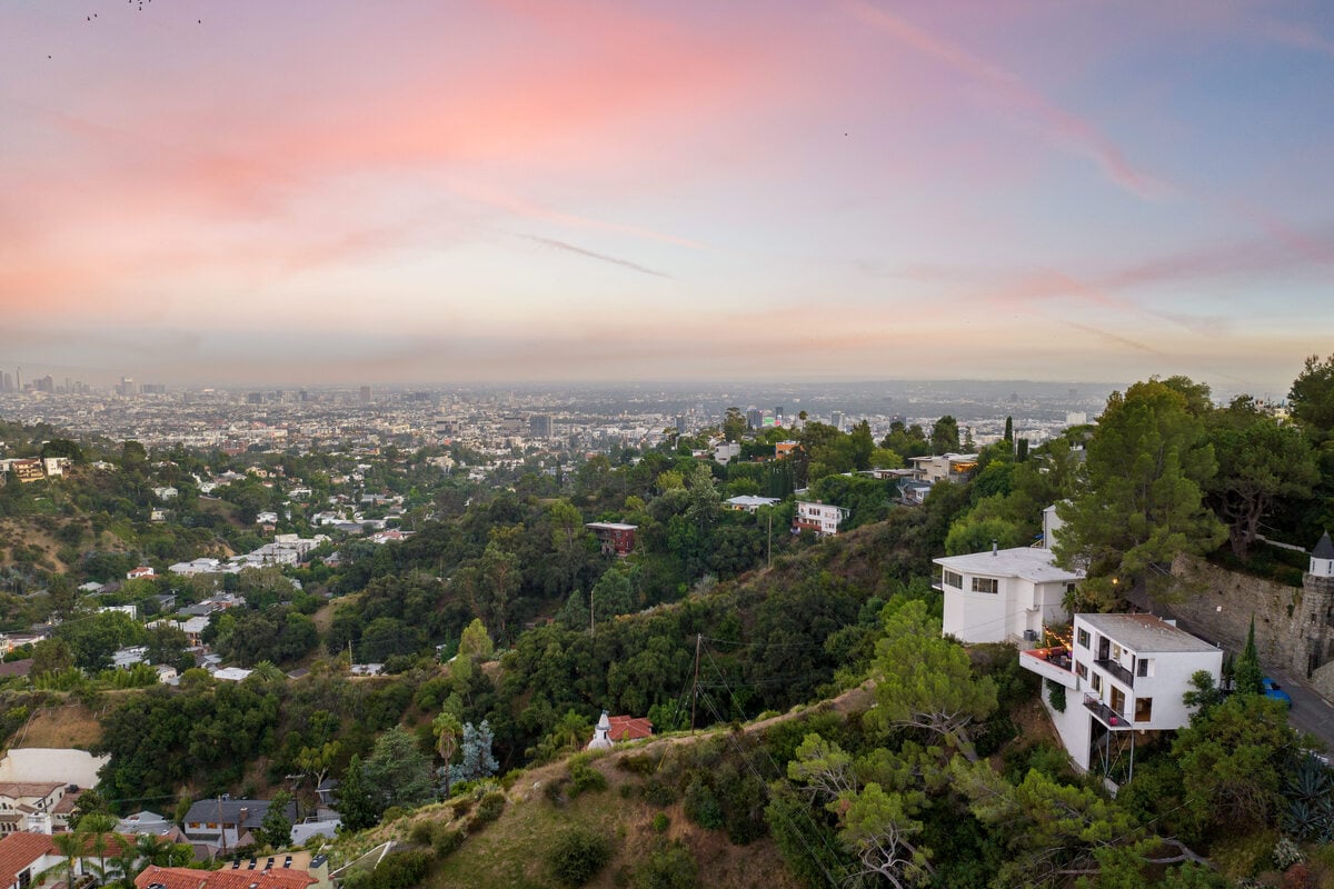 Scenic view of green hills and suburban homes in Los Angeles at sunset, California
