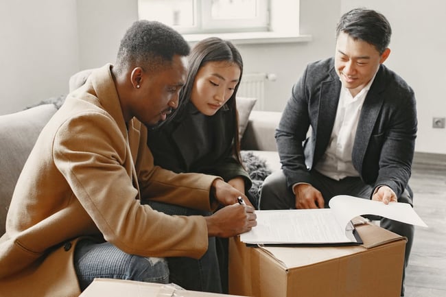 two people signing a lease being presented by an agent two people signing a lease being presented by an agent